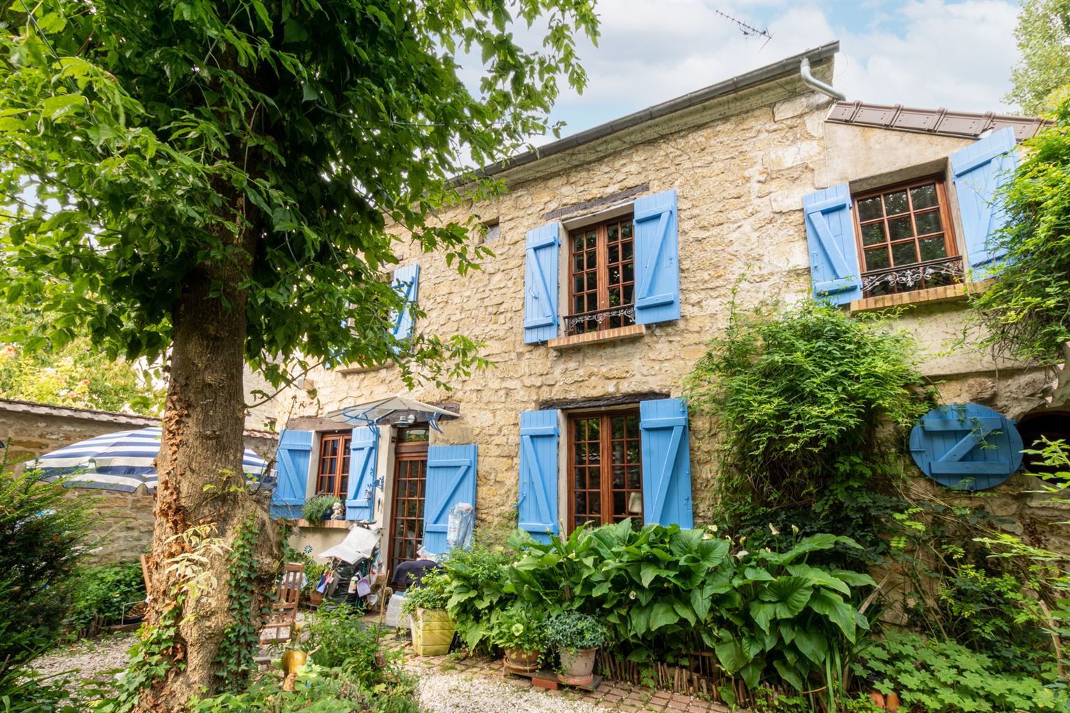 Maison en pierres aux volets bleus